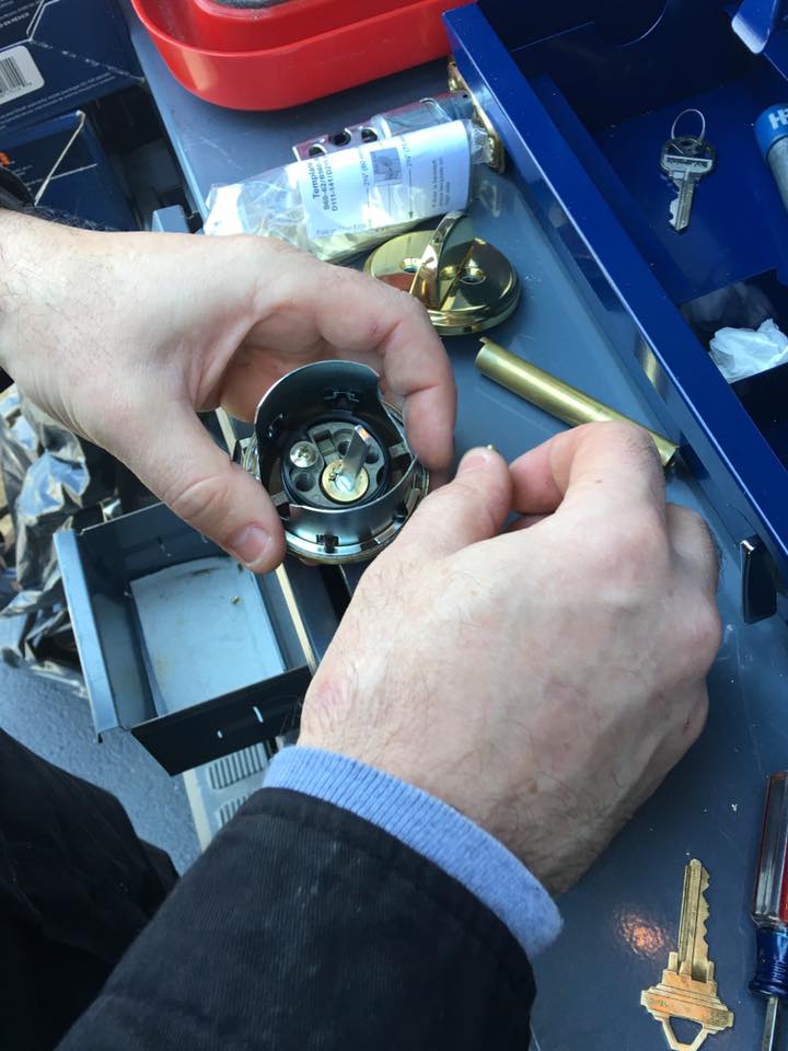 A person working on some parts of a door knob.
