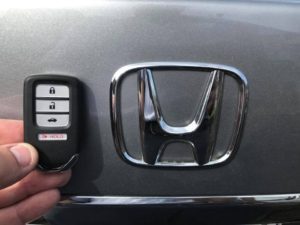 A person is holding the remote for a honda car.